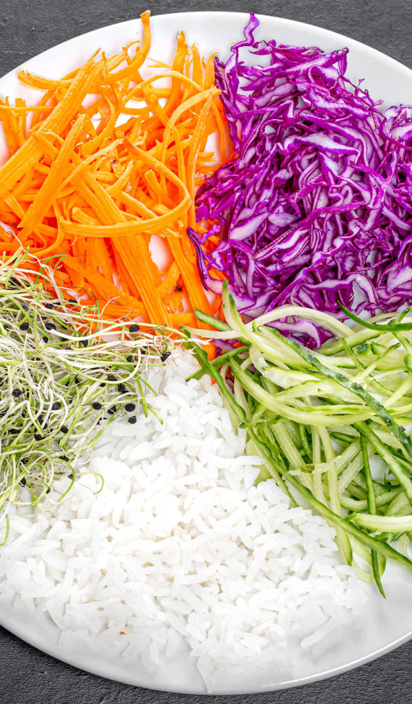 Овощи с рисом на большой  белой тарелке на сером столе 