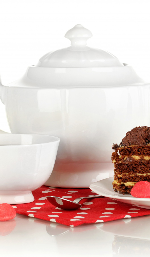 Белая чашка чая и чайник на столе с куском торта