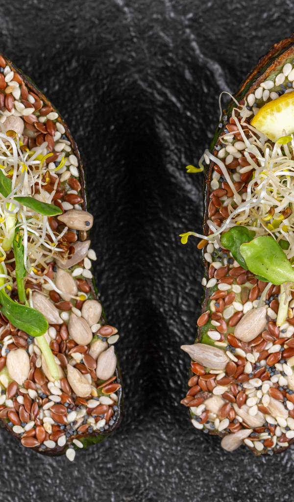 Половинки авокадо с проросшими зернами на столе