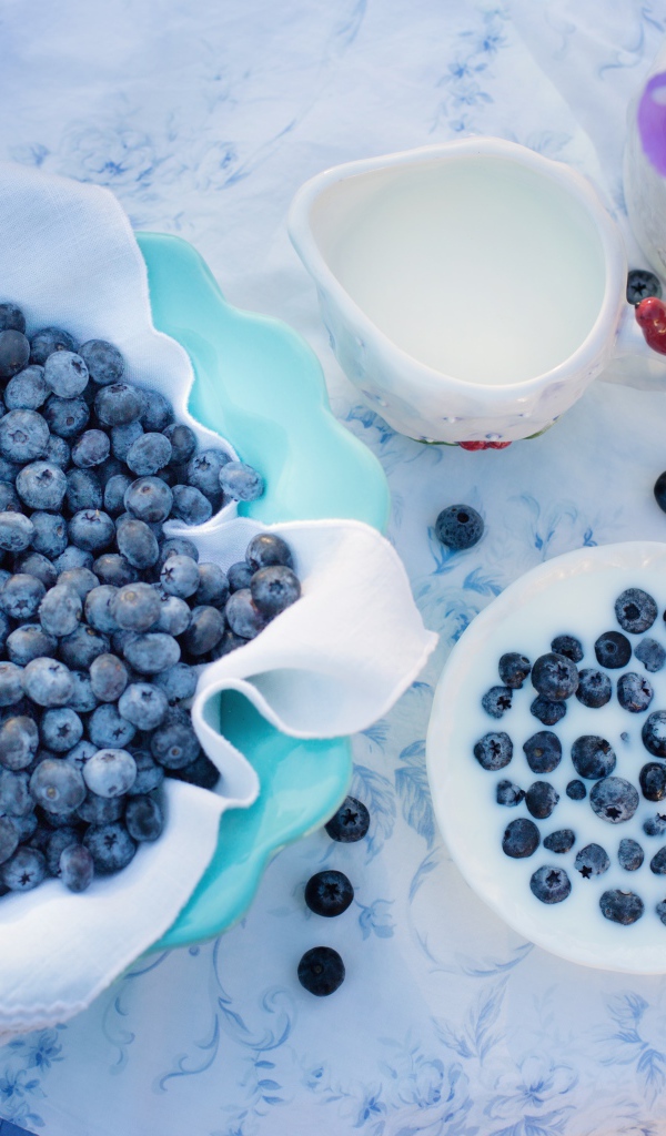 Синие ягоды черники на столе с молоком 