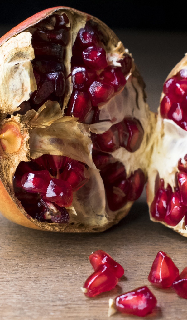 Разломанный красный гранат на столе 