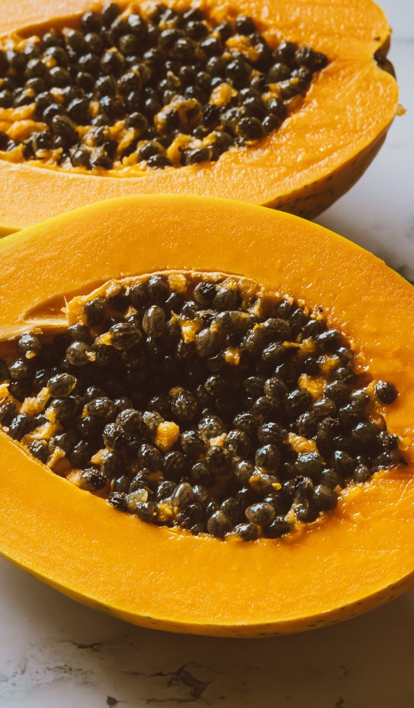 Разрезанный плод папайи на столе 