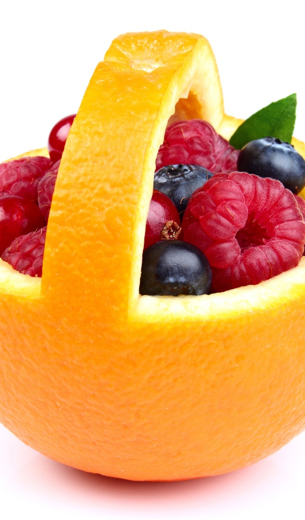 Свежие ягоды в кожуре апельсина на белом фоне