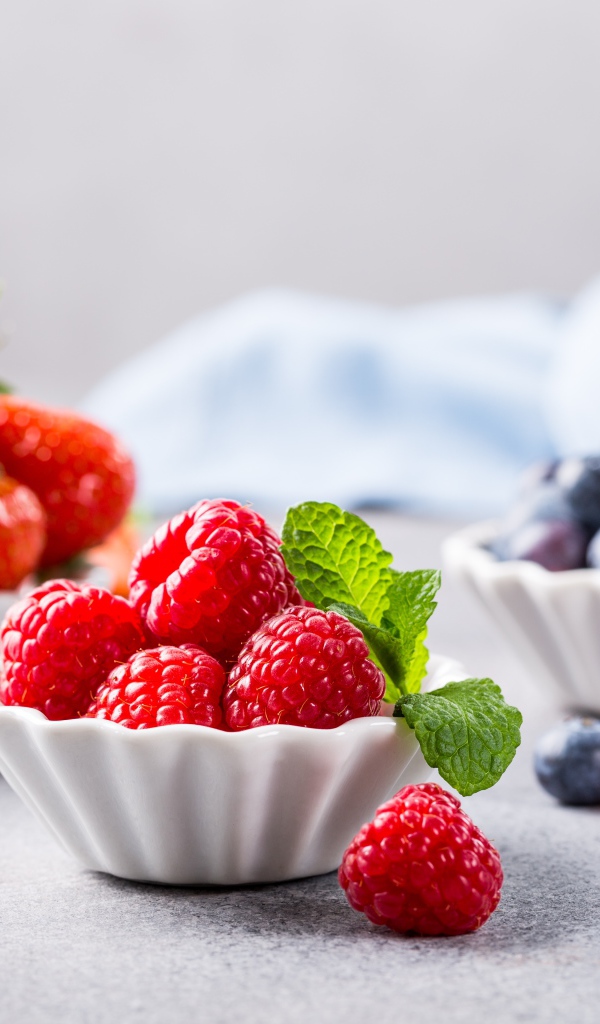 Свежие ягоды малины, клубники и черники на столе