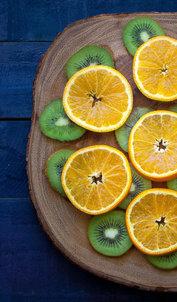 Кружочки киви с апельсинами на доске 