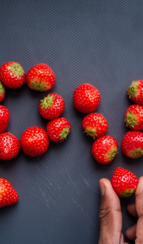 Надпись LOVE выложена из ягод спелой клубники 