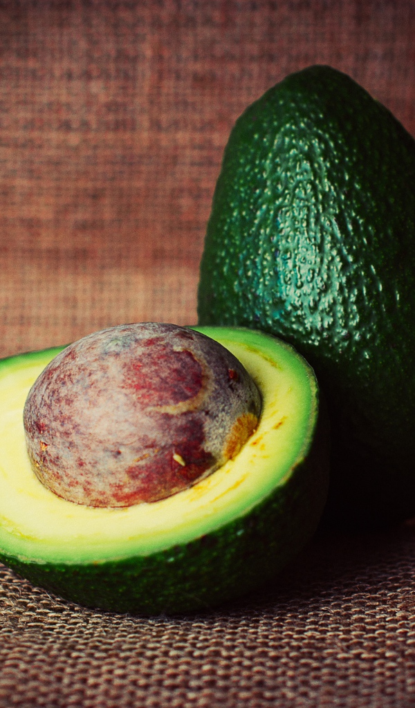 Большой зеленый плод авокадо с круглой косточкой