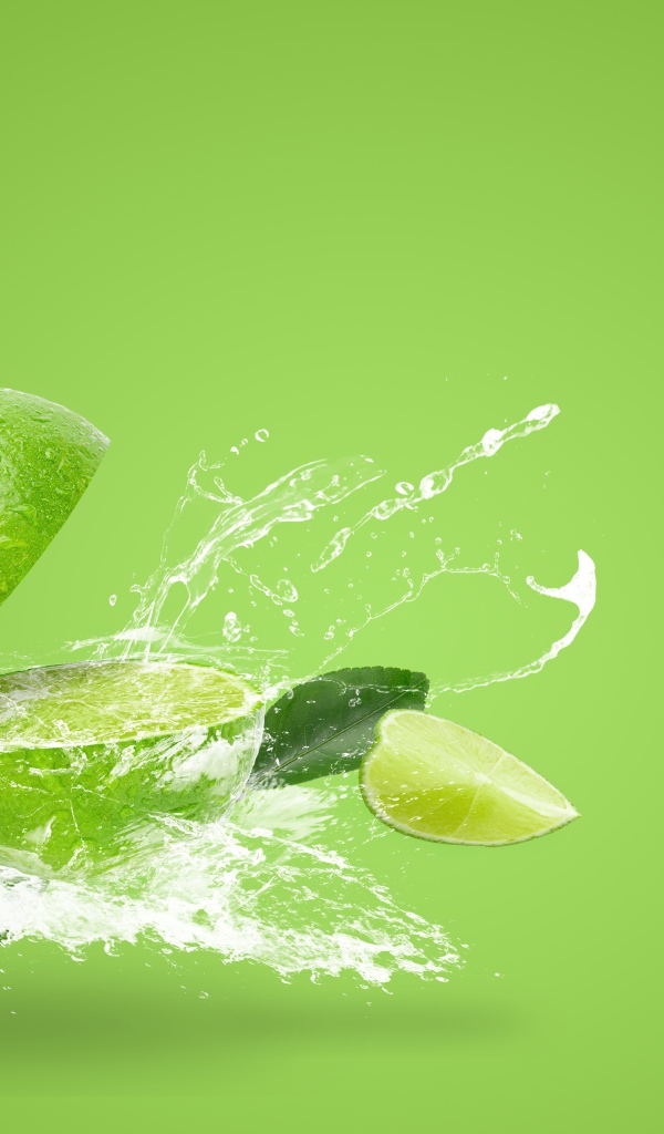 Лайм в брызгах воды на зеленом фоне