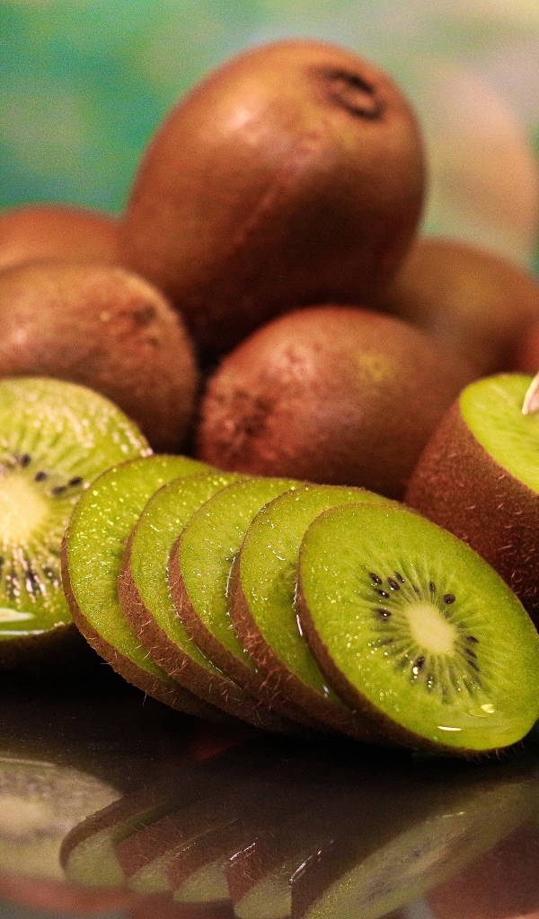 Много спелых плодов киви на столе с ложкой 