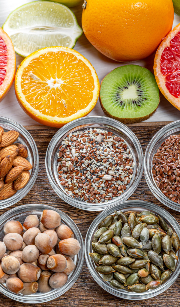 Орехи, зерна и цитрусовые фрукты на столе