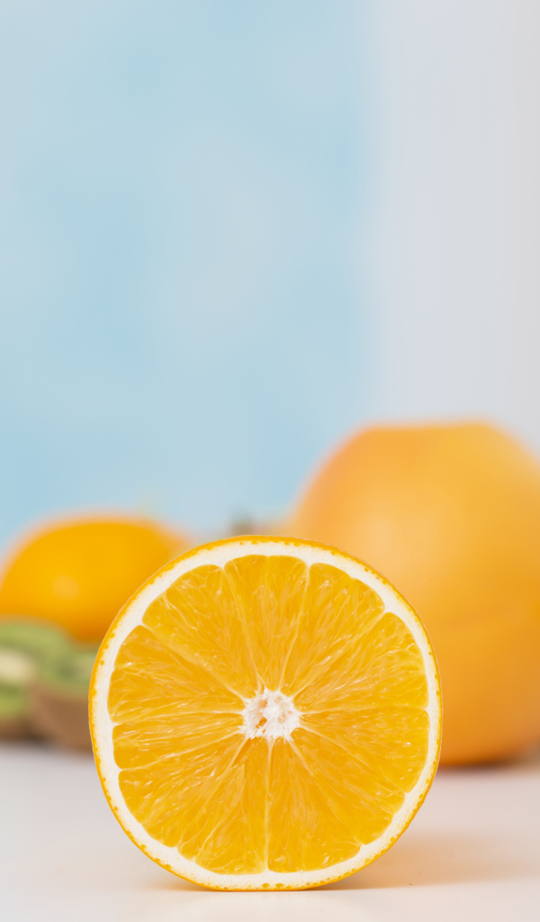 Оранжевые апельсины с киви на столе 