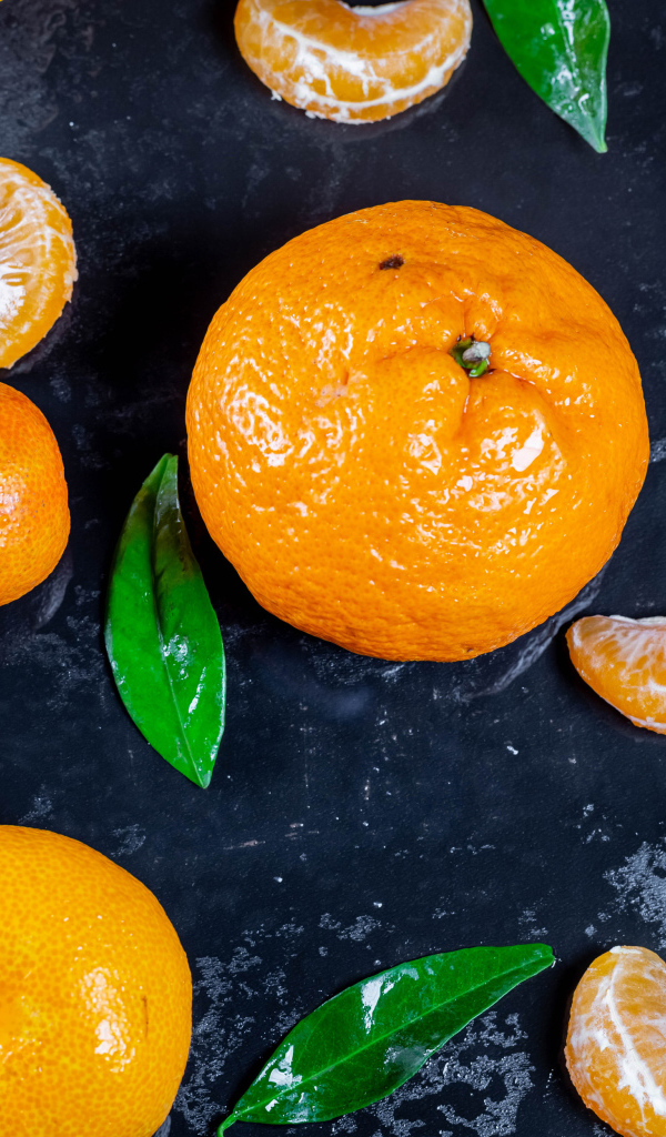 Оранжевые мандарины на мокрой поверхности 