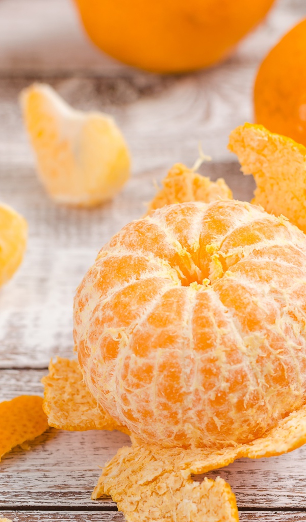 Очищенный мандарин на деревянном столе 