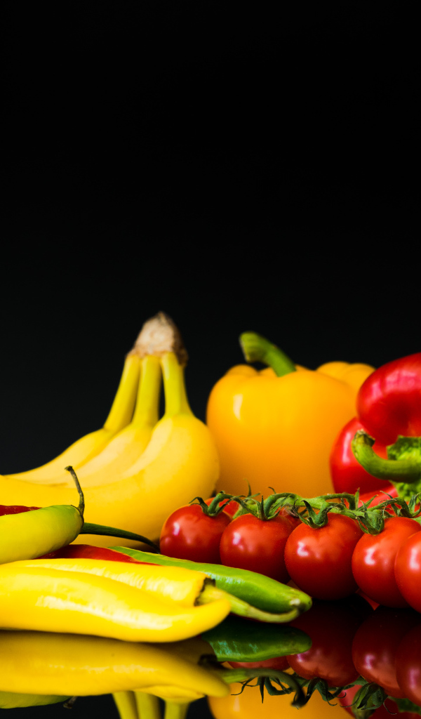 Перец, помидоры и бананы на черном фоне