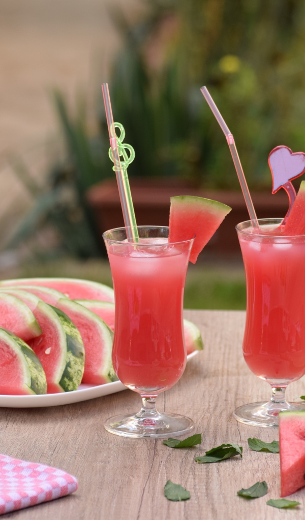 Куски арбуза на столе с коктейлем