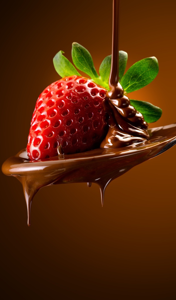 Красная клубника на ложке с молочным шоколадом