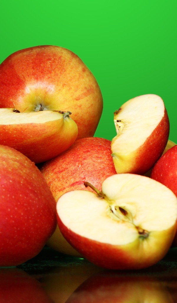 Спелые вкусные красные яблоки на зеленом фоне