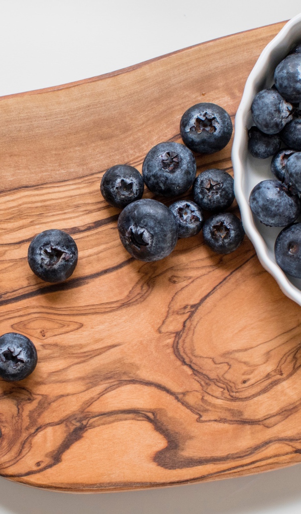 Спелые крупные ягоды черники на доске