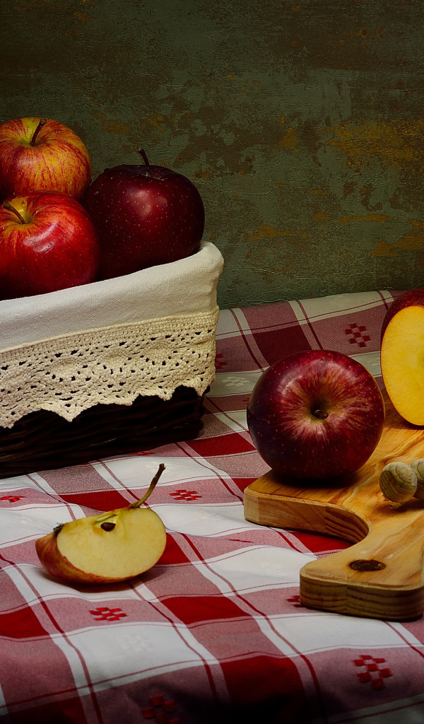 Спелые красные яблоки на столе с ножом