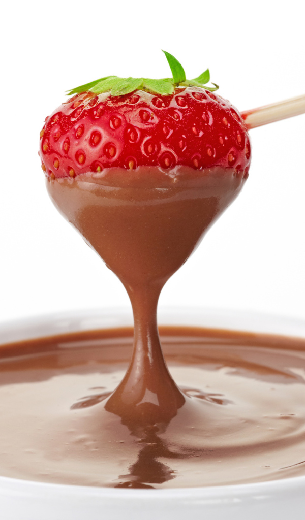 Спелая клубника в молочном шоколаде на белом фоне