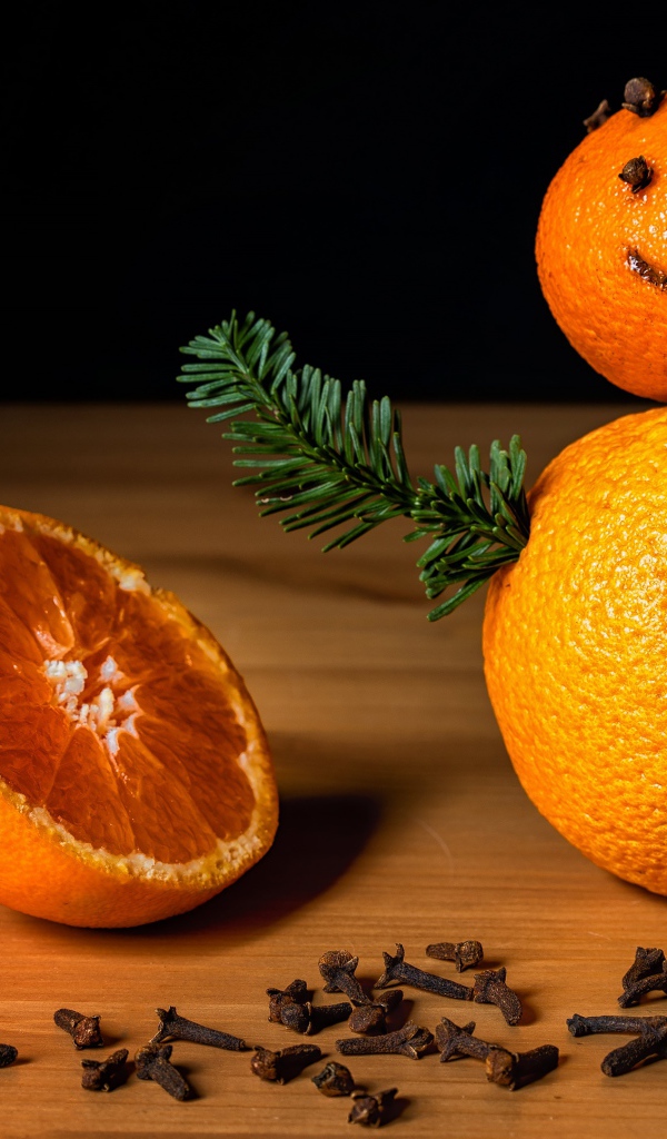 Снеговик из мандаринов и корицы на столе 