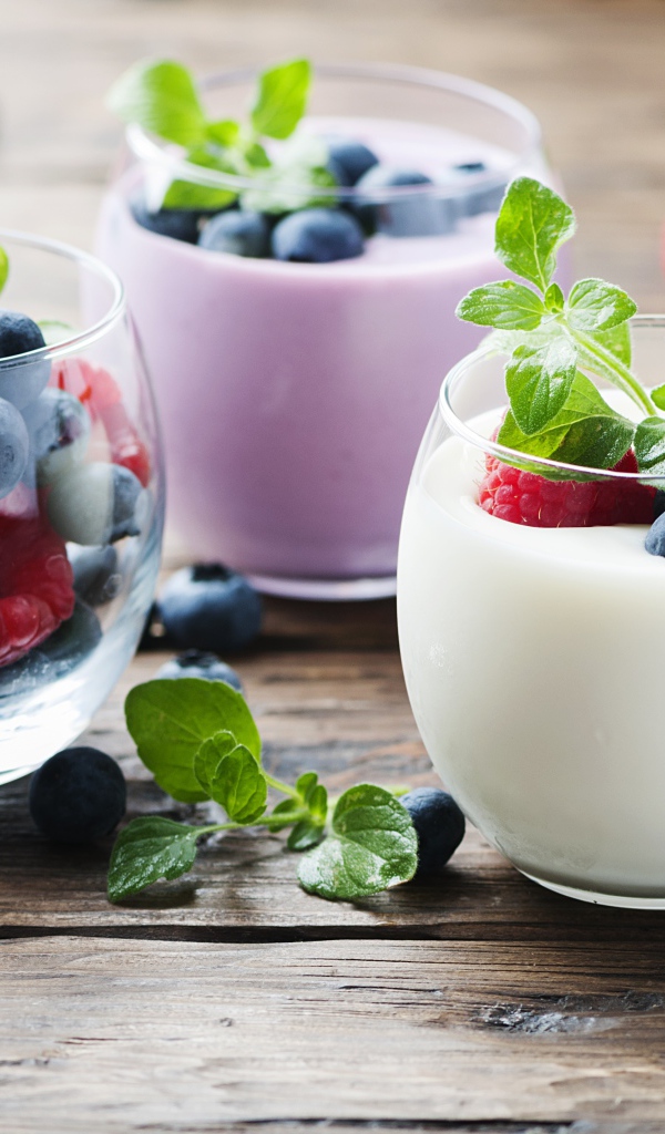 Вкусный йогурт с ягодами черники и малины на столе 