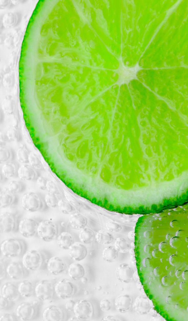Два куска лайма в пузырях в воде 