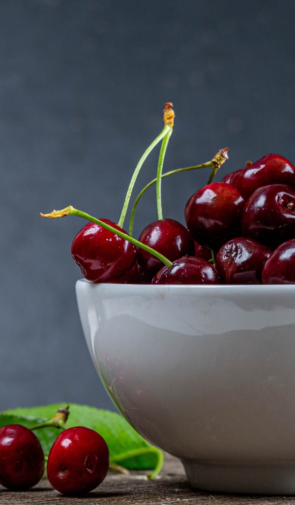 Белая фарфоровая тарелка с красной спелой черешней 