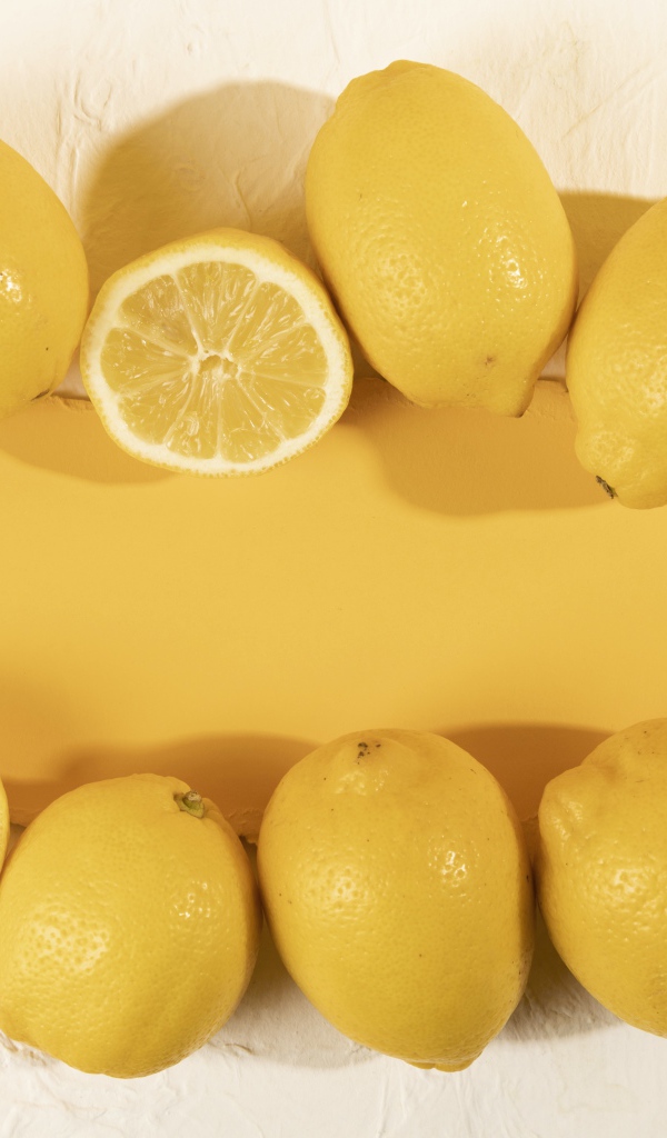 Желтые лимоны на белом фоне с листом бумаги