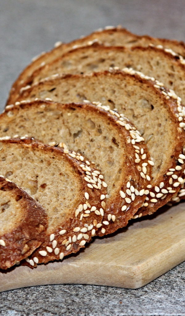 Свежий хлеб нарезан на доске на столе 