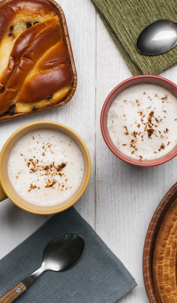 Свежая выпечка и две кружки молока на столе