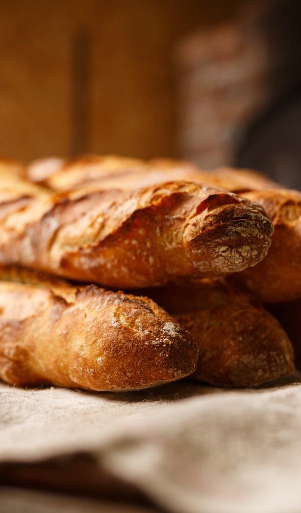 Много штук румяного длинного батона на столе 