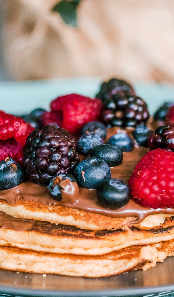 Румяные оладьи с ягодами на тарелке 