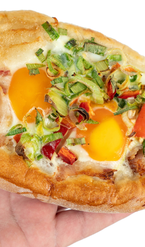 Вкусный свежий хачапури с яйцом и беконом в руке