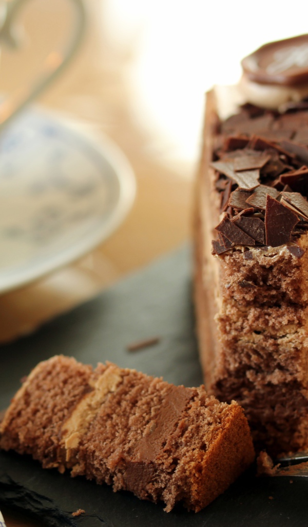 Кусок торта с шоколадом на столе с кофе