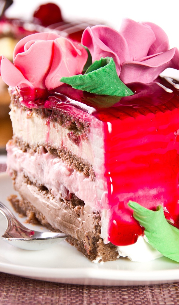 Кусок аппетитного торта декорирован розами из крема