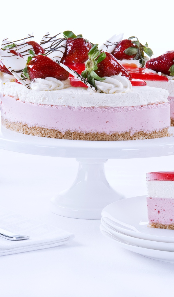 Аппетитный праздничный торт с клубникой на столе 