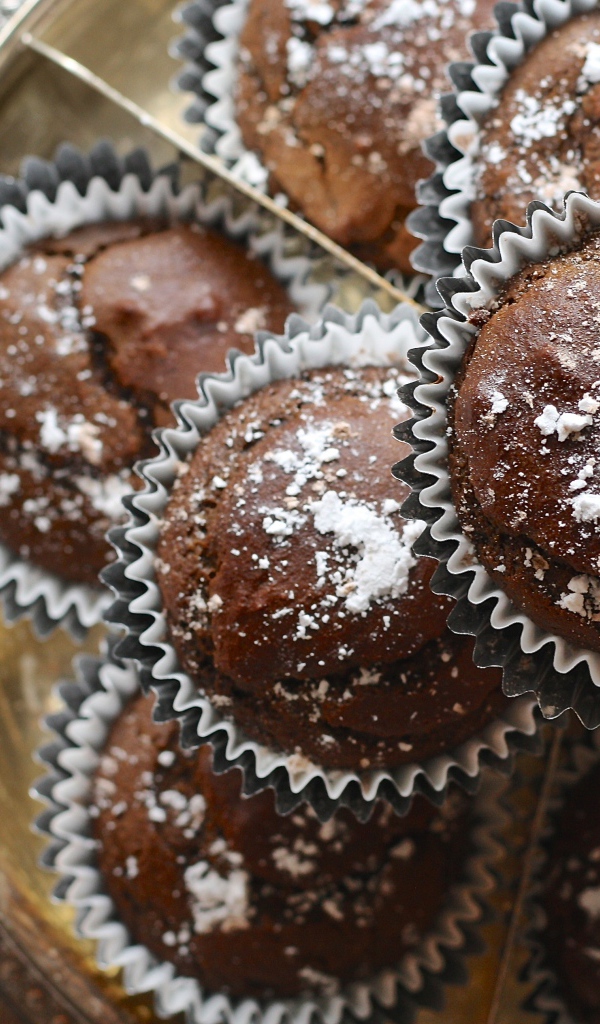 Аппетитные кексы с сахарной пудрой на столе 