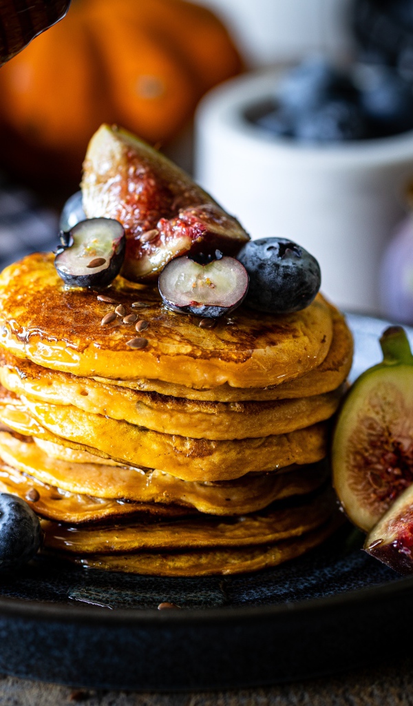 Аппетитные оладьи на тарелке с ягодами черники и инжиром