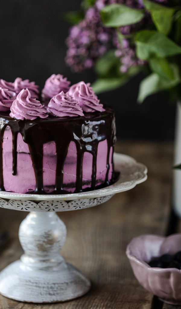 Ягодный торт с шоколадом на столе с сиренью 