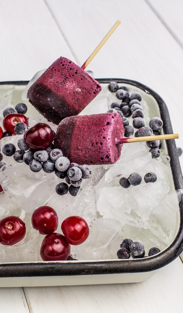 Ягодное мороженое в лотке со льдом, черникой и вишней 