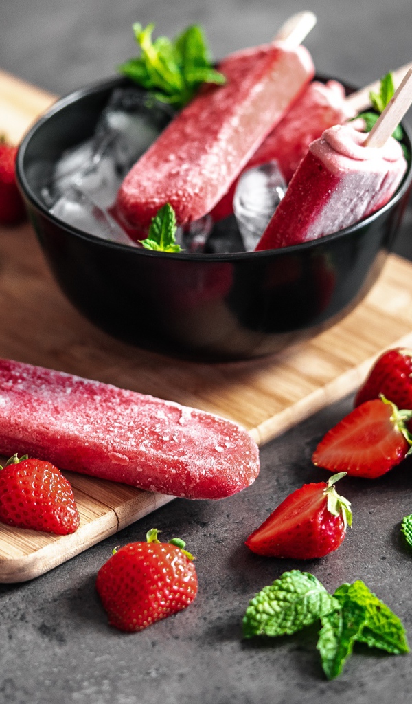 Ягодное мороженое с клубникой и мятой на столе 