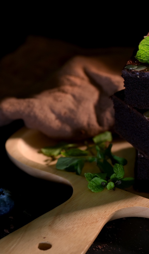 Шоколадный десерт брауни на доске с ягодам черники 