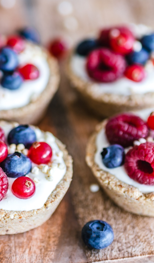 Пирожные с кремом и ягодами на столе крупным планом