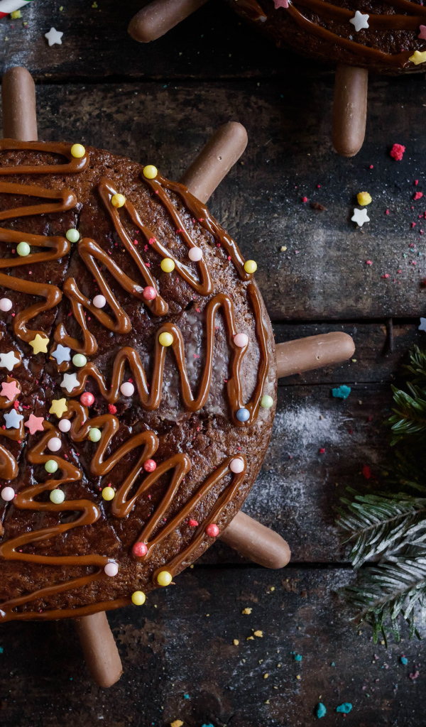 Шоколадное пирожное на столе с еловыми игрушками 