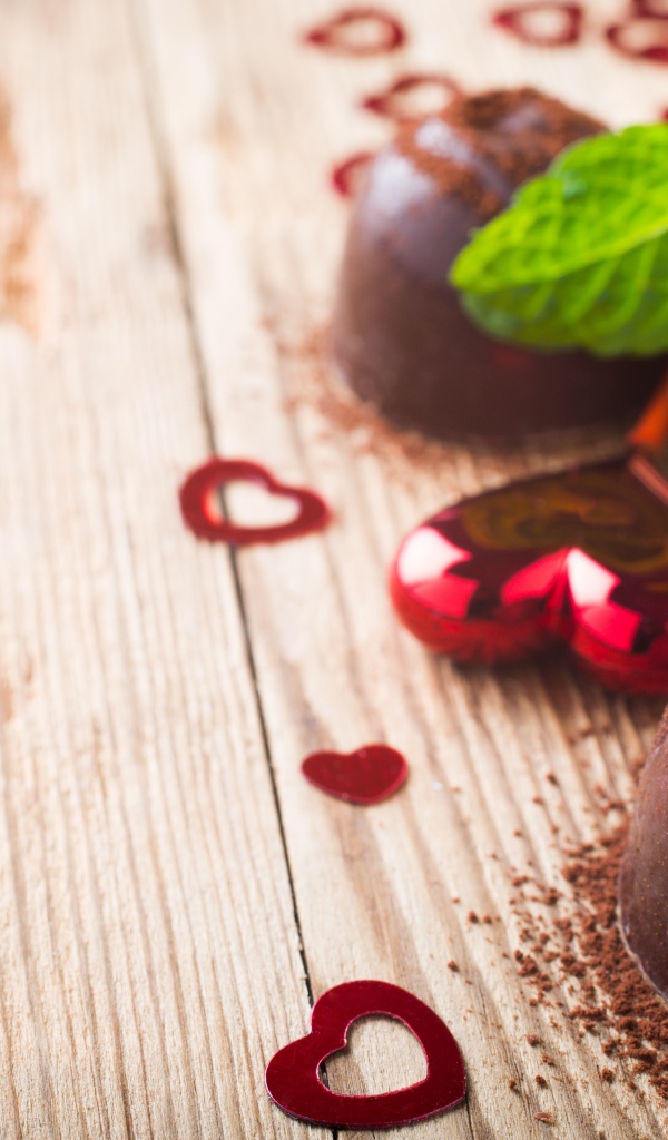 Шоколадные конфеты с какао на столе с мятой и сердечками