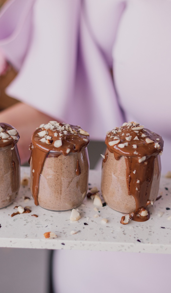 Шоколадный десерт в банках в руках у девушки