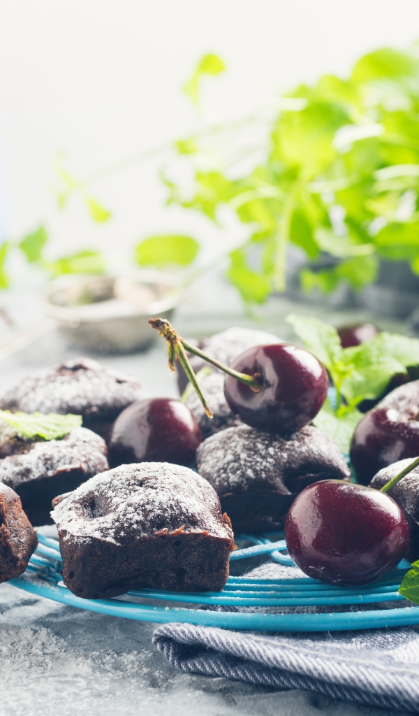 Шоколадные кексы на тарелке с ягодами черешни 