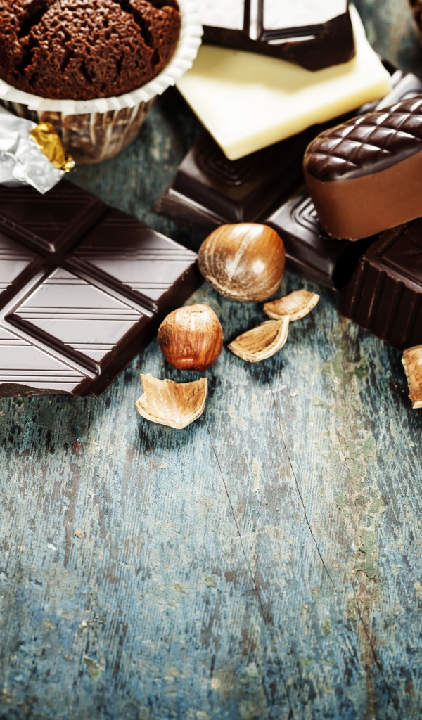 Шоколад на столе с орехами, кексами и конфетами 