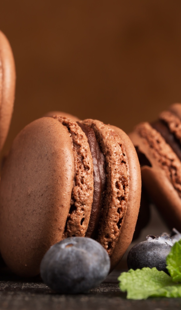 Шоколадный десерт макарон на столе с черникой 